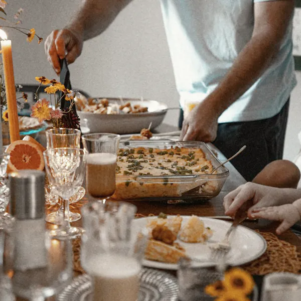 A guest serves from a baking dish at the end of the table
