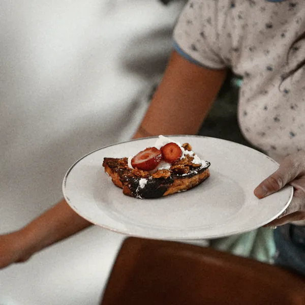 A plate of strawberry French toast carried to the table